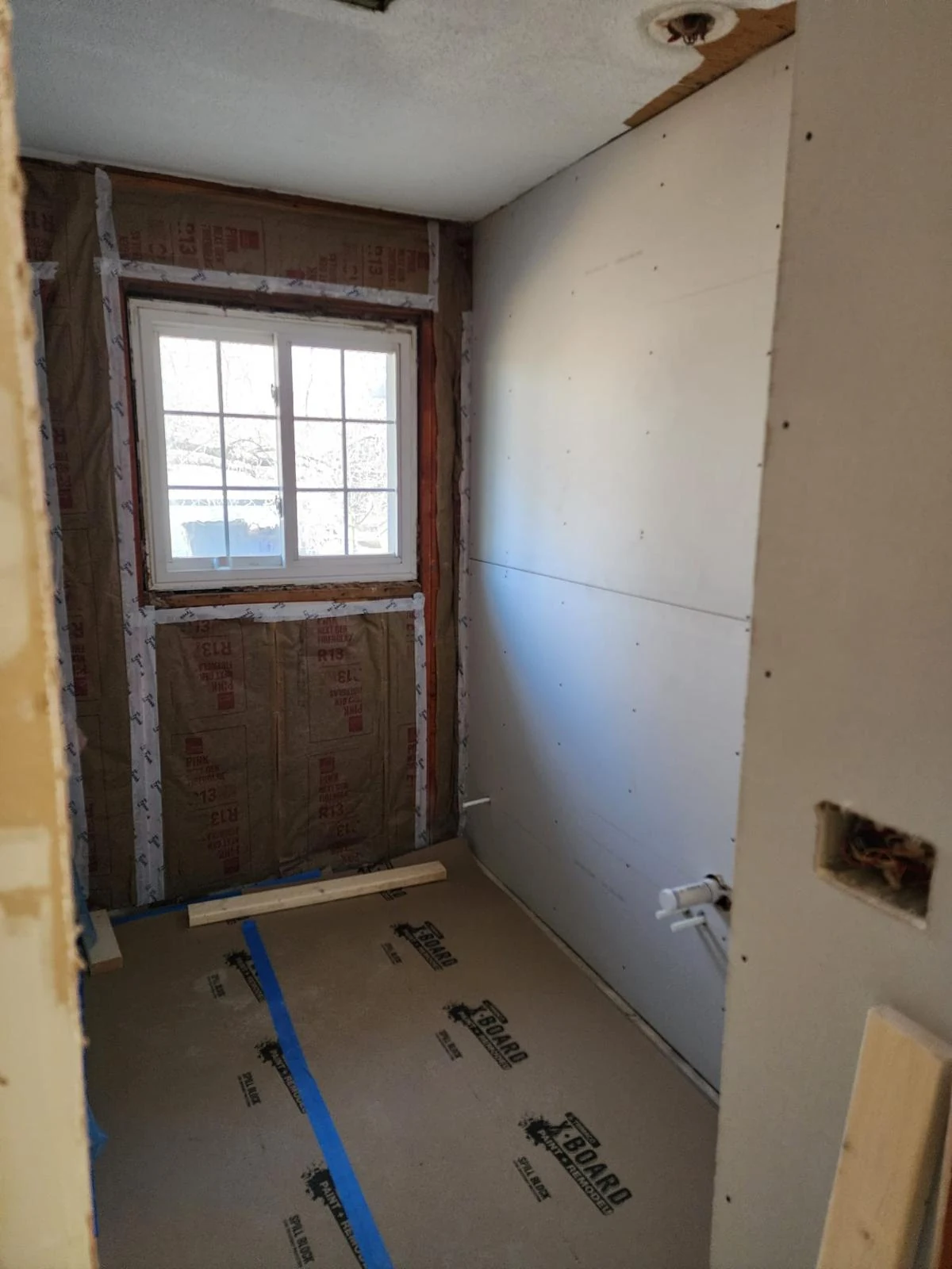 Bathroom renovation showing newly installed drywall sheets and unfinished walls