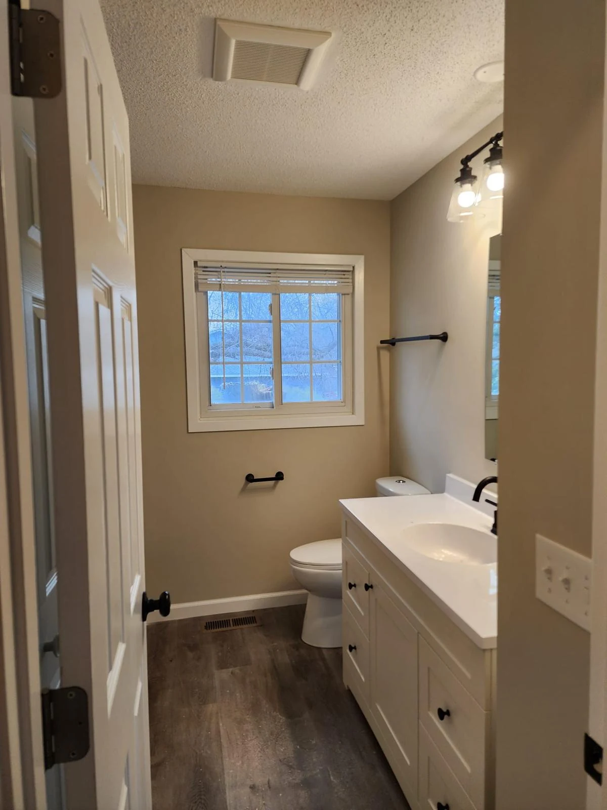 Finished bathroom with painted walls, white vanity and black fixtures