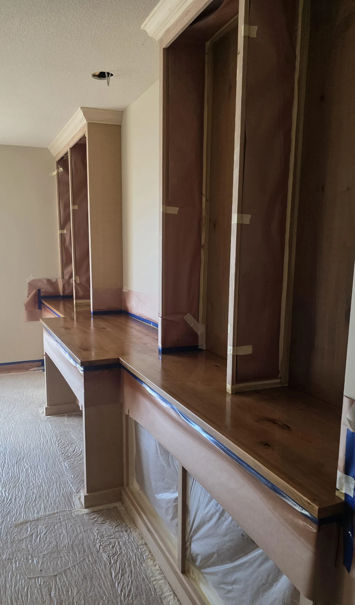 Built-in shelving and wood surfaces carefully masked with paper for finishing