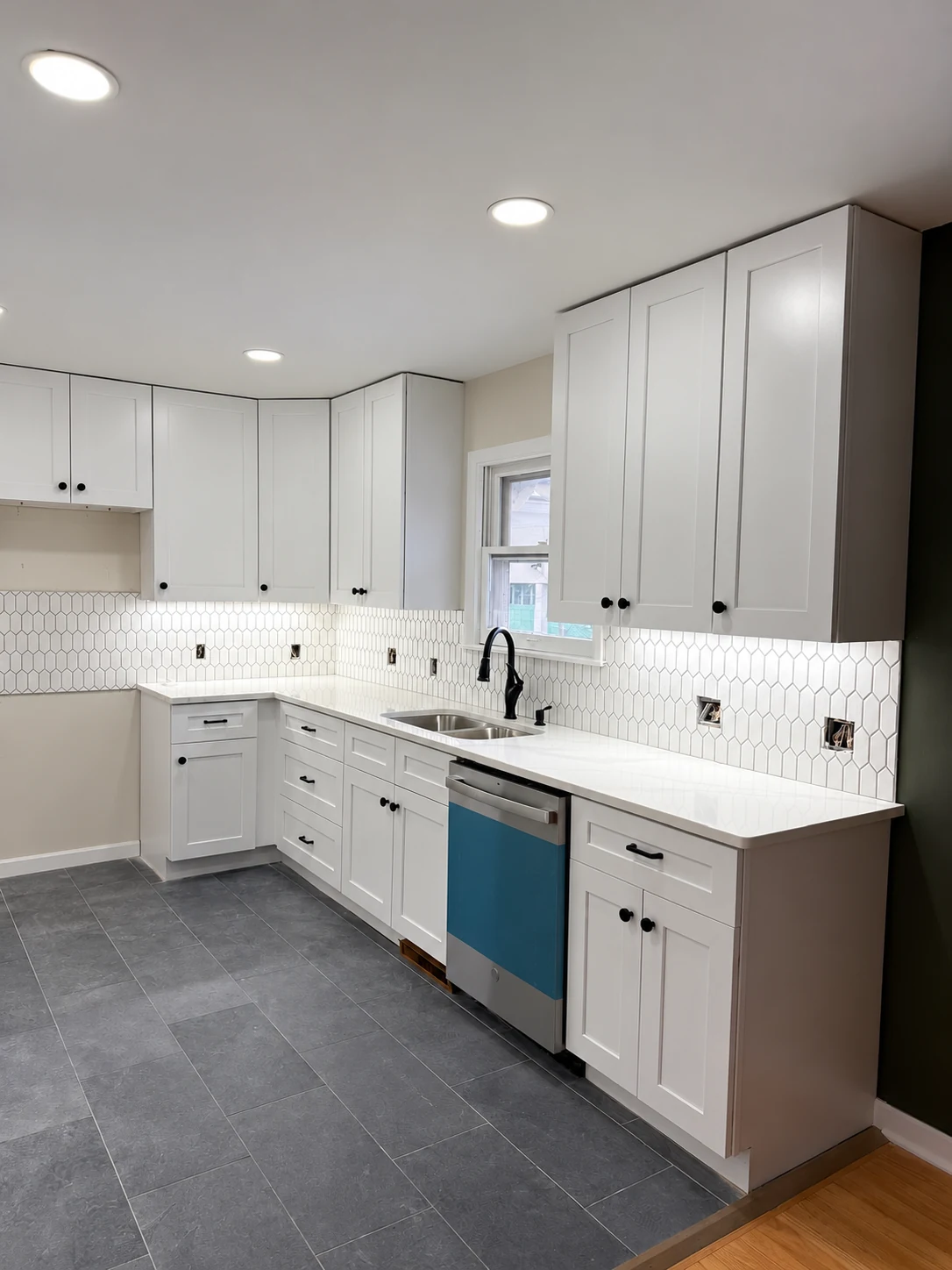 White shaker-style kitchen cabinets, tiled backsplash and completed countertops