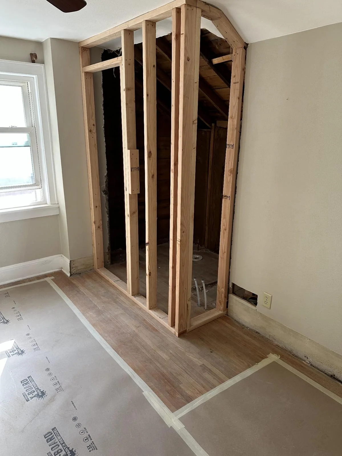 Wood framing for a newly built interior partition beside a window