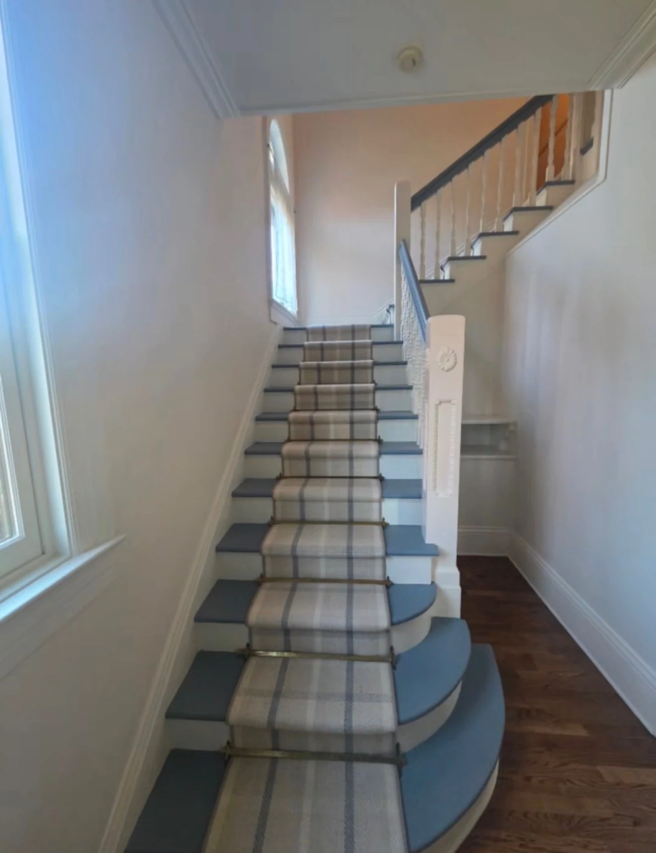 Staircase with striped carpet runner and painted step edges