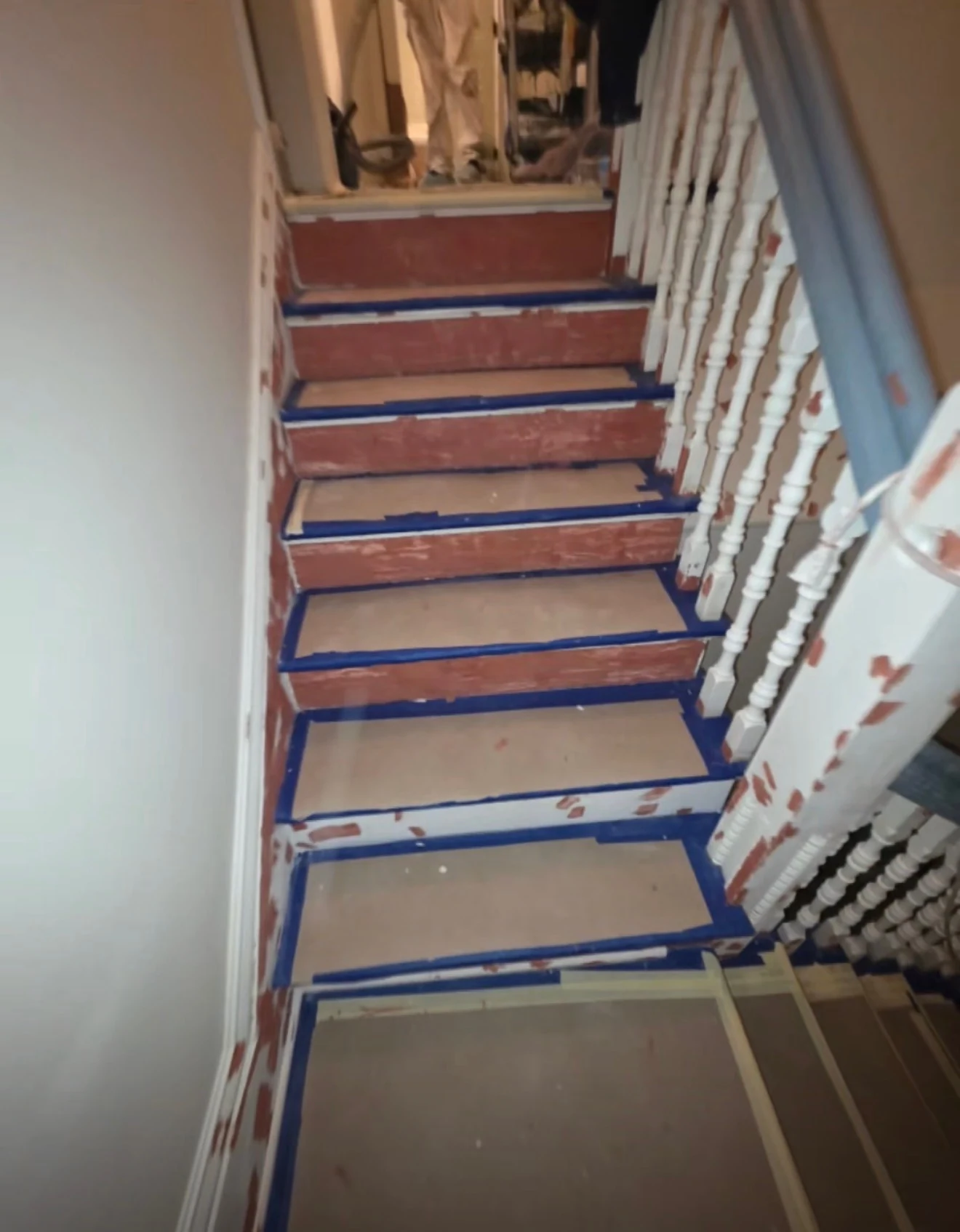 Staircase during renovation with masking tape and protected stair treads