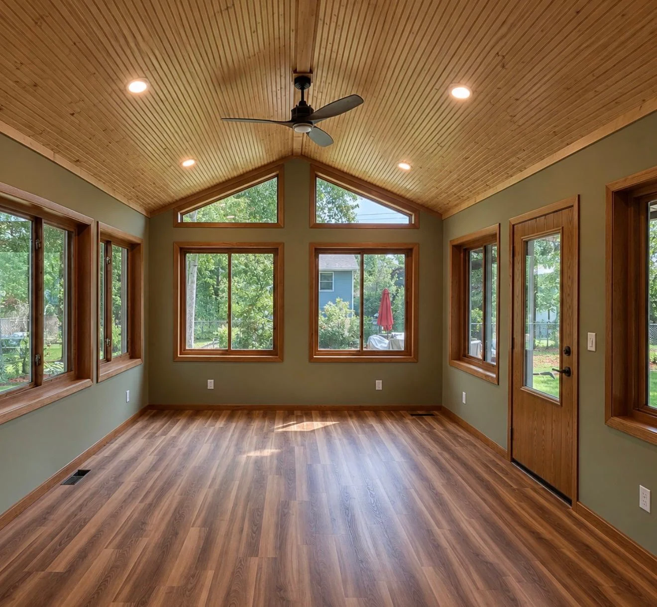 Finished tongue-and-groove wood ceiling with recessed lights and ceiling fan
